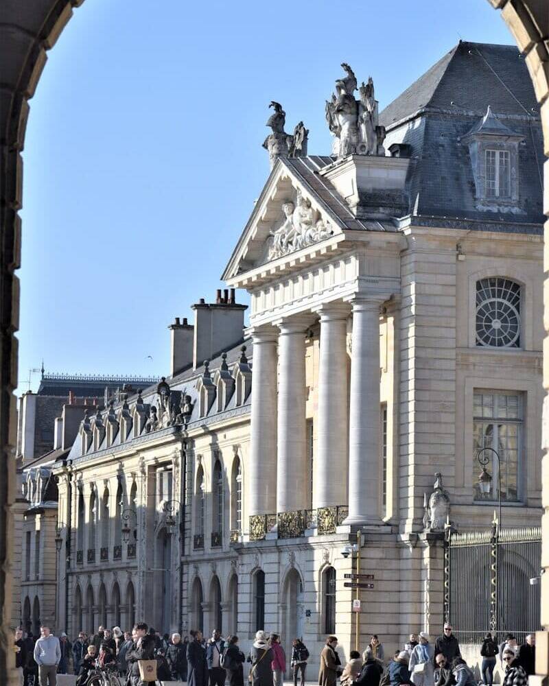 a group of people walking in front of a large building