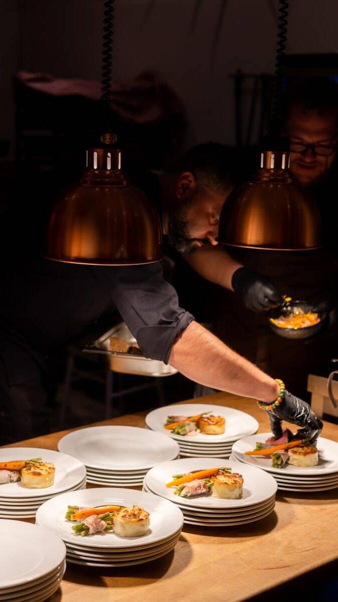 a couple of men sitting at a table with plates of food