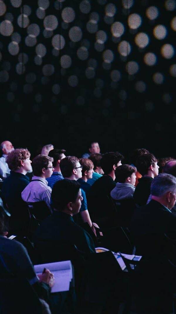 crowd of people sitting on chairs inside room